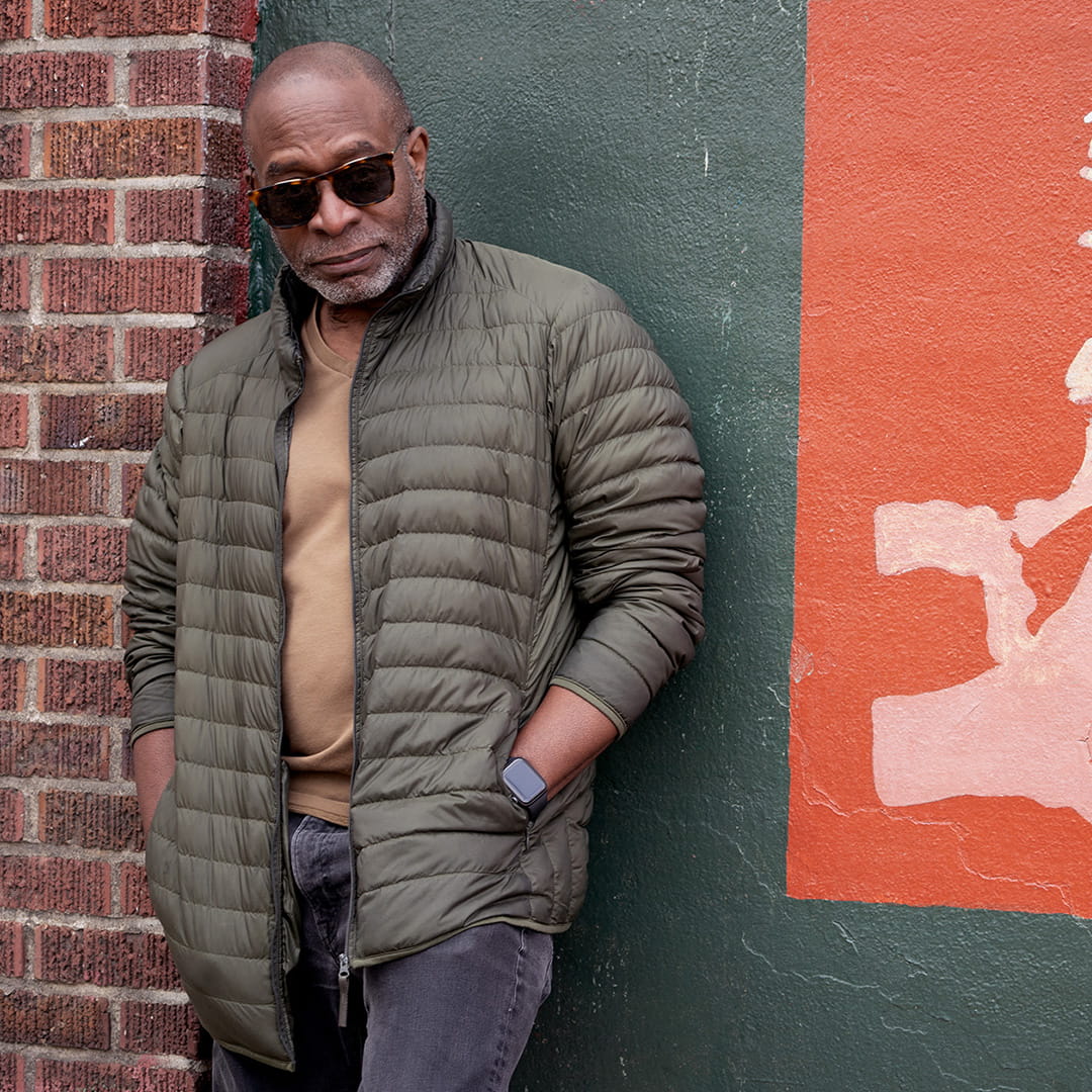 Brian Jackson vor einem Gebäude mit Sonnenbrille