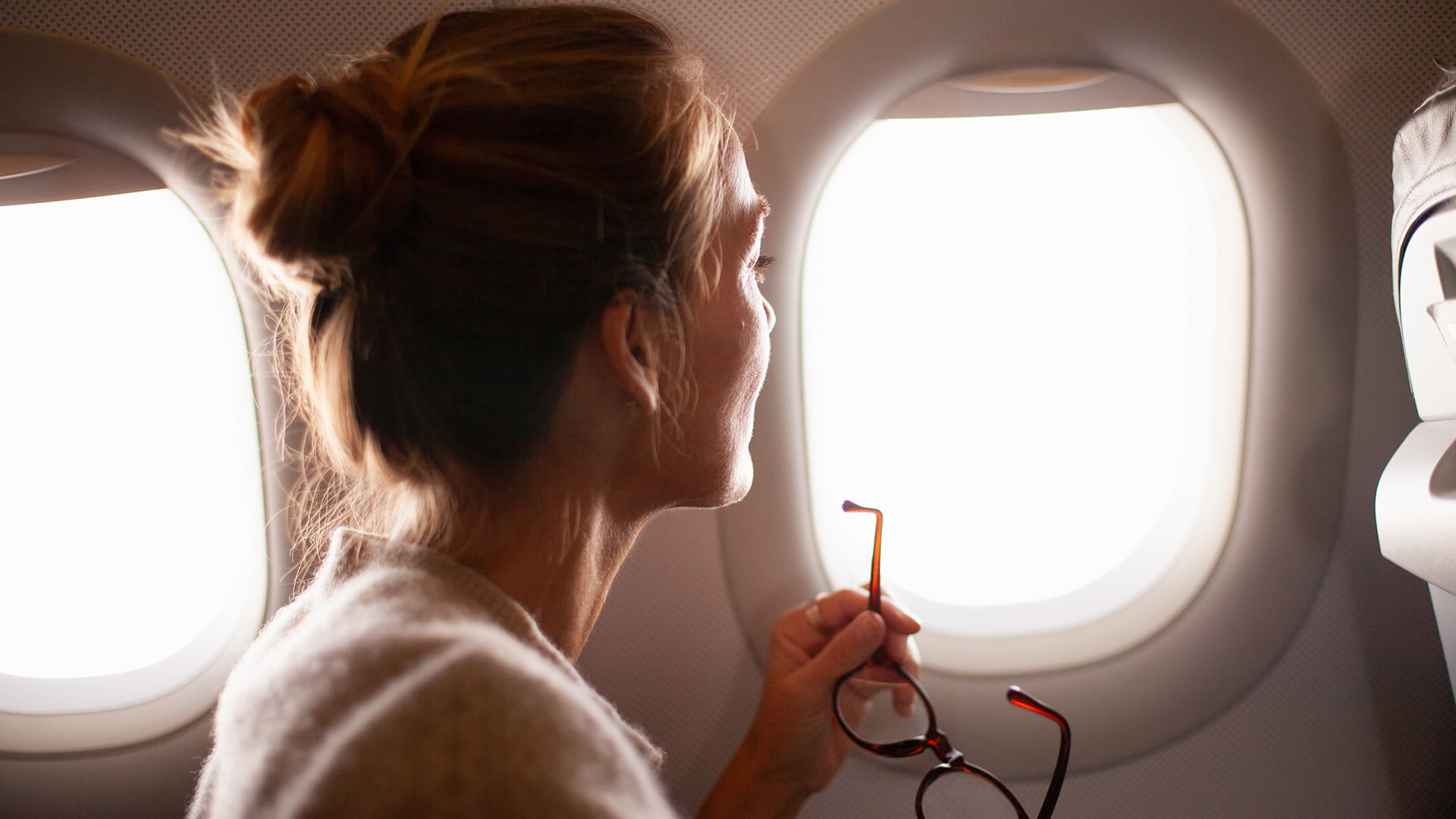 woman looking out of airplane window