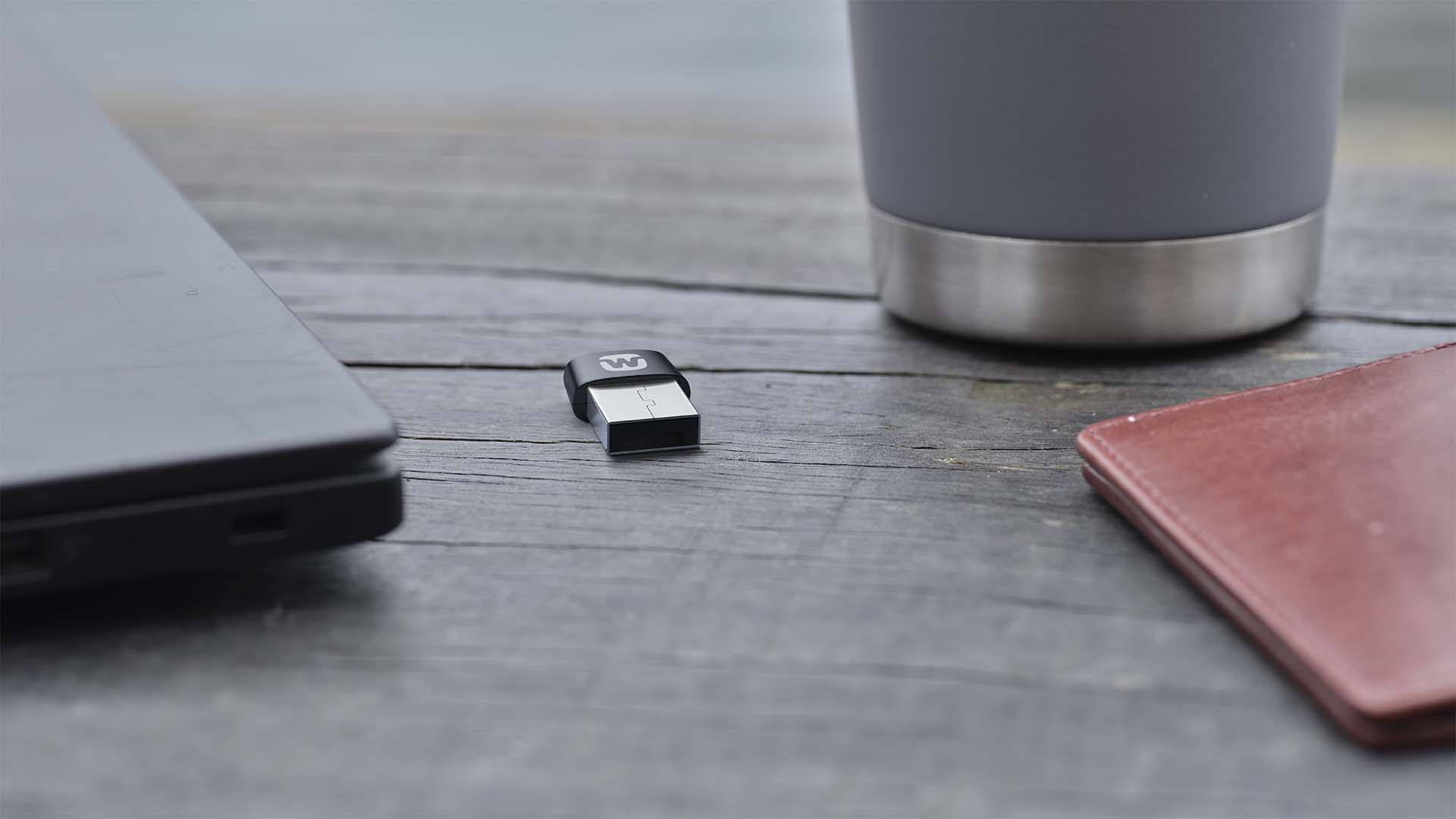 Widex SoundConnect streaming accessory next to a travel mug