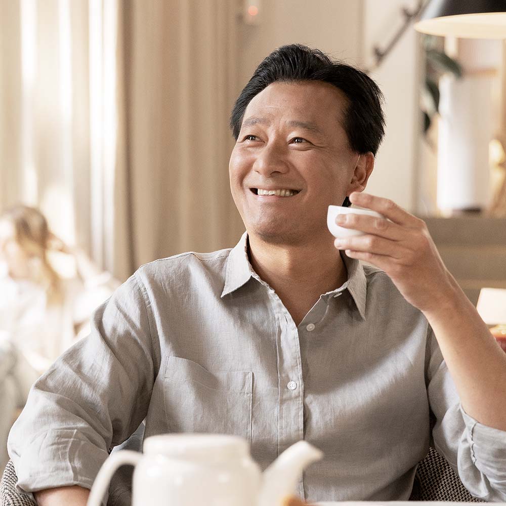 Man smiling and holding a cup