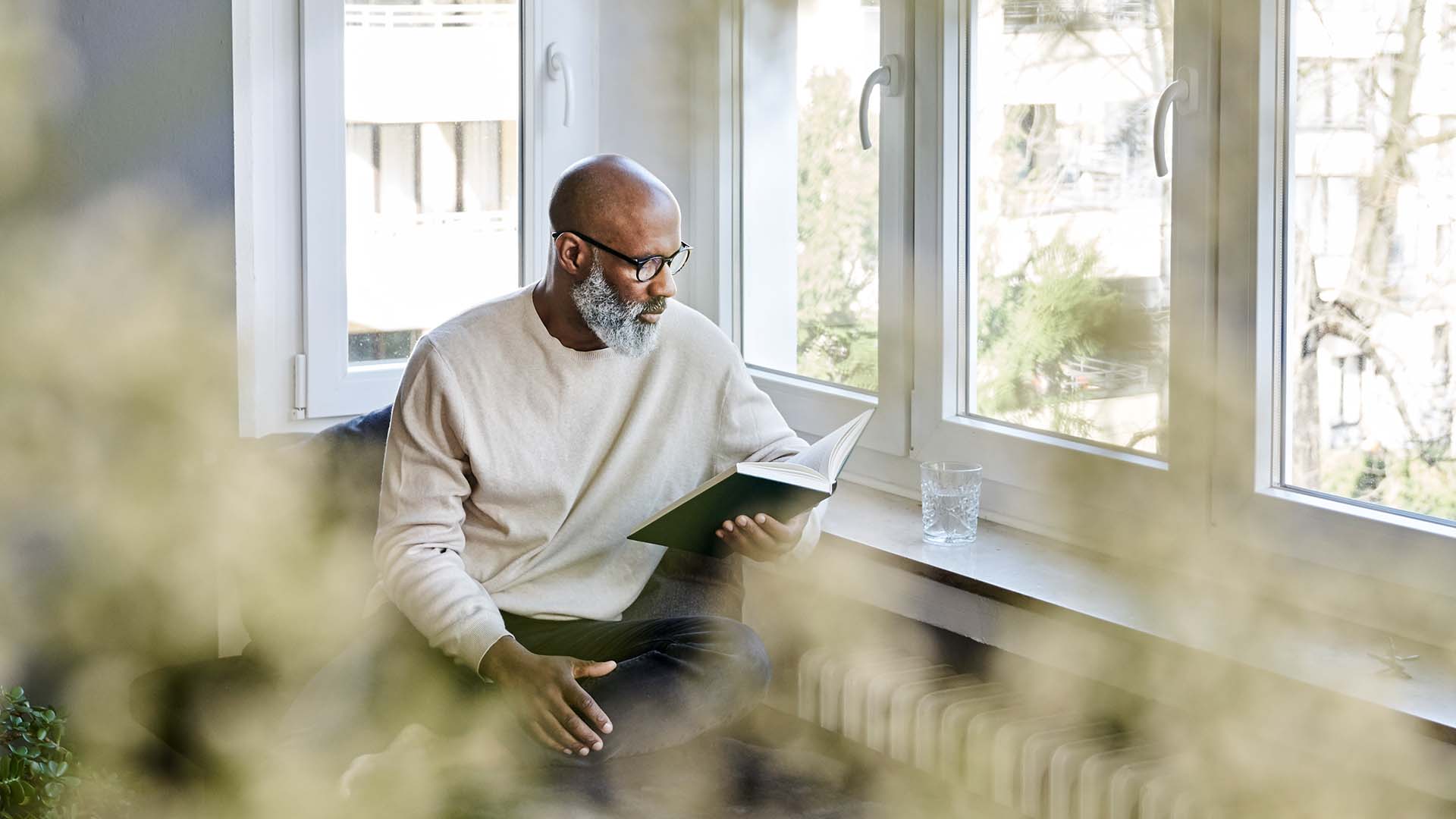 Man sitting at window and reading