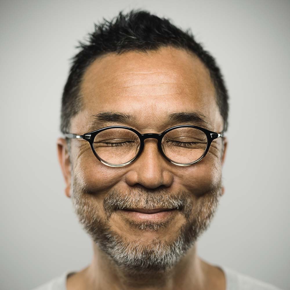Man with glasses and closed eyes is smiling