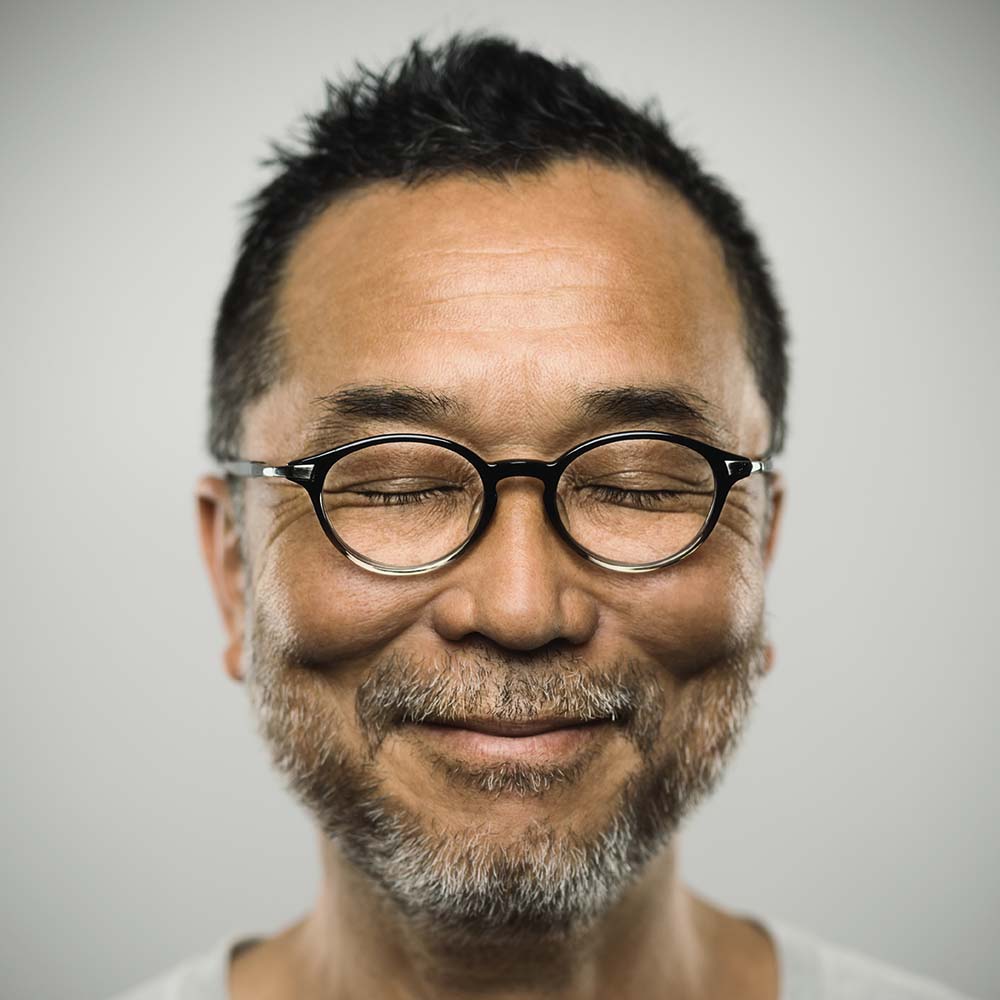 Man with glasses and closed eyes is smiling