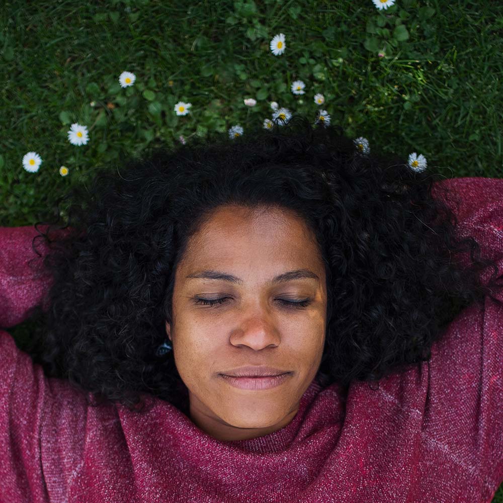 Woman lying on grass, eyes closed