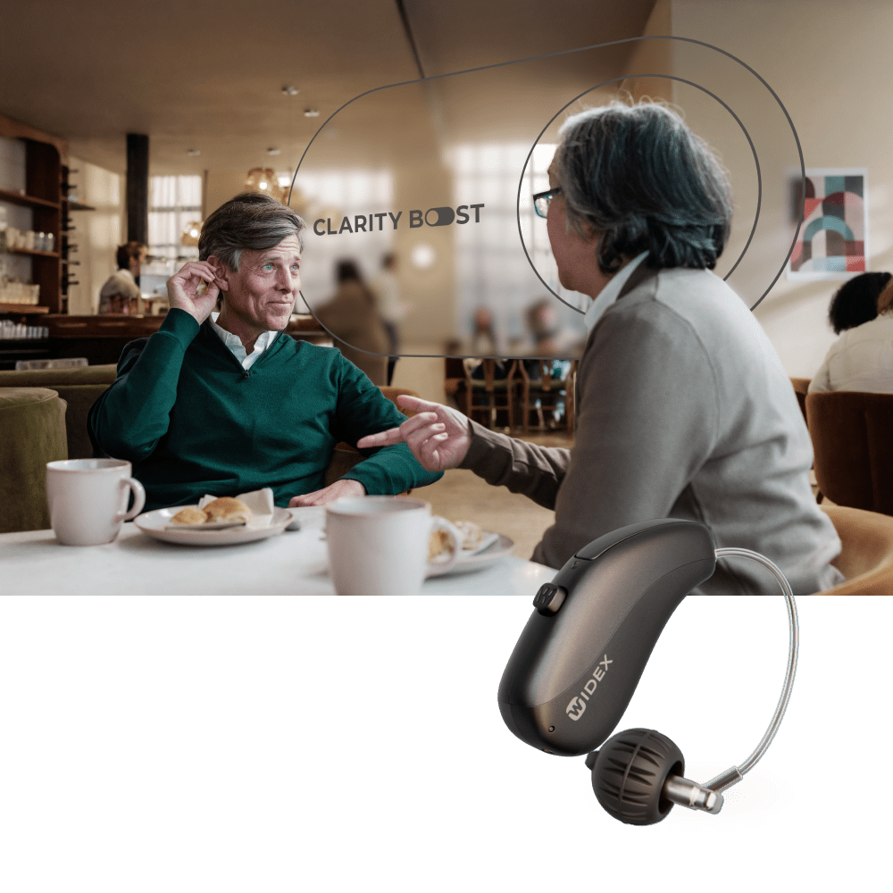Een drager van een hoortoestel die in een druk café een gesprek voert met iemand anders en de Clarity Boost-functie van het Widex Allure AI RIC-hoortoestel gebruikt om zich op het gesprek te concentreren